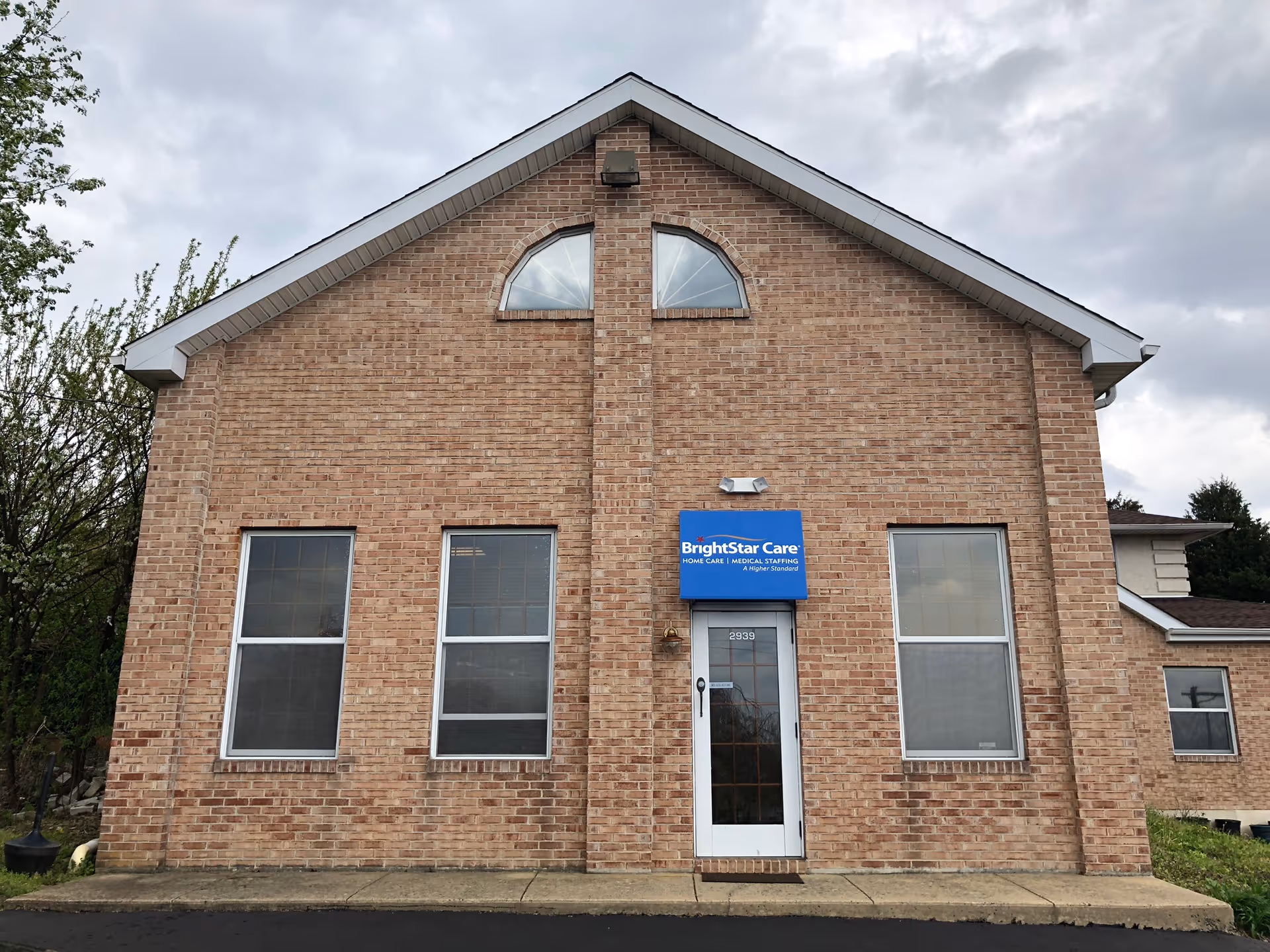 Brick BrightStar Care building exterior with blue sign above the front door.
