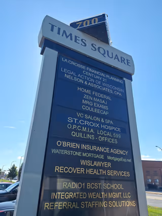 Tall exterior sign reading Times Square with multiple business names listed on a blue panel