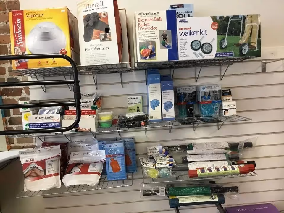 Metal wire shelves stocked with medical supplies and equipment against a brick wall.