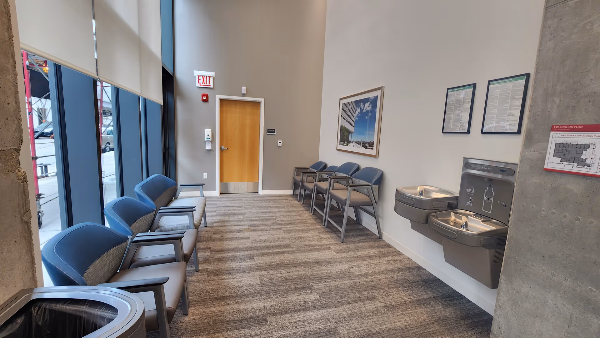 Interior waiting area with blue chairs, water fountain, and large windows in Rush West Loop.