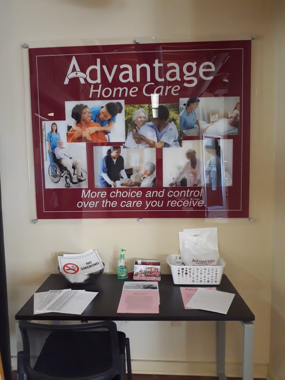 Interior desk area featuring an Advantage Home Care poster and organized paperwork.