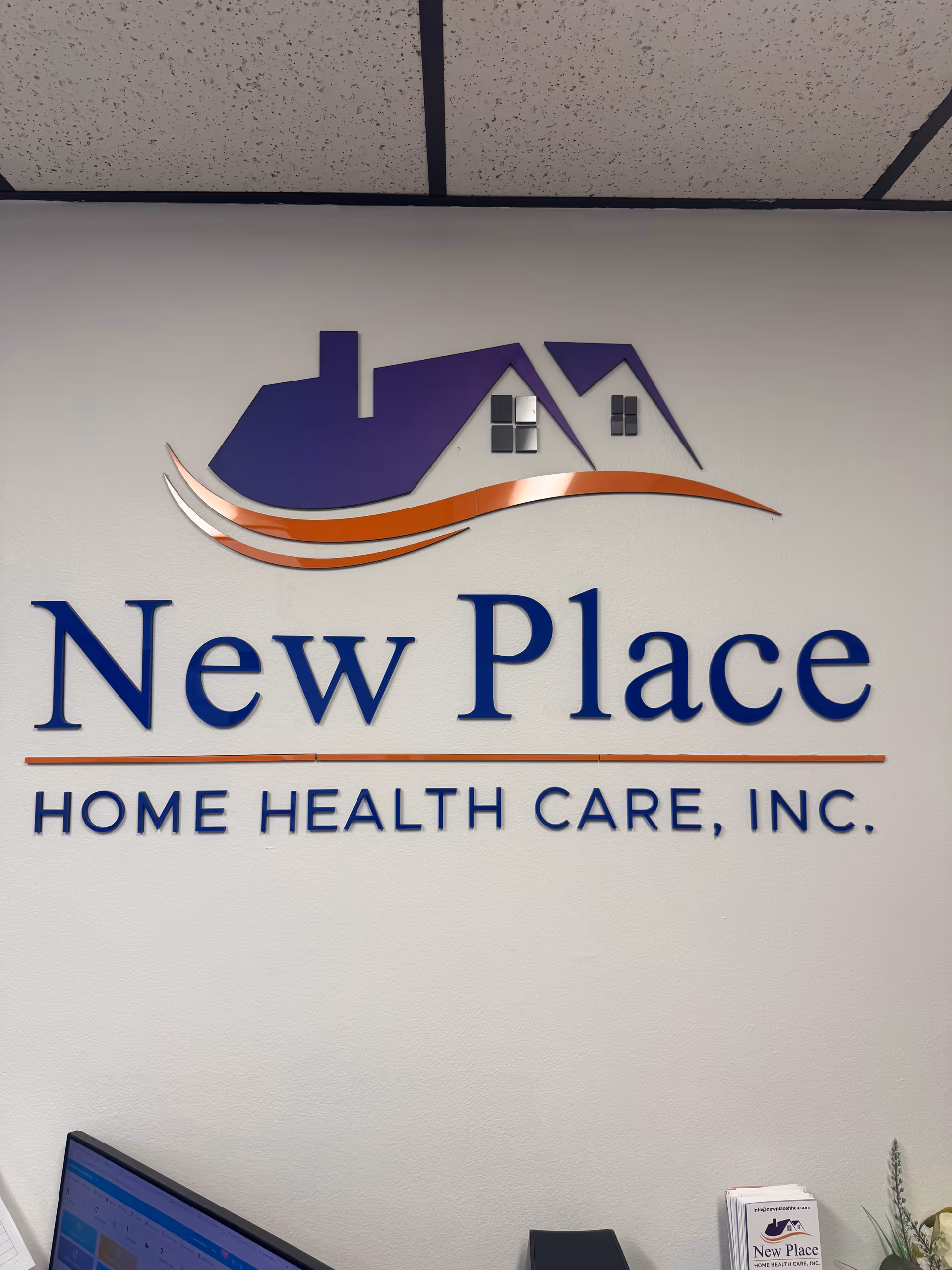 Interior wall signage displays 'New Place Home Health Care, Inc.' with purple house-shaped logo.