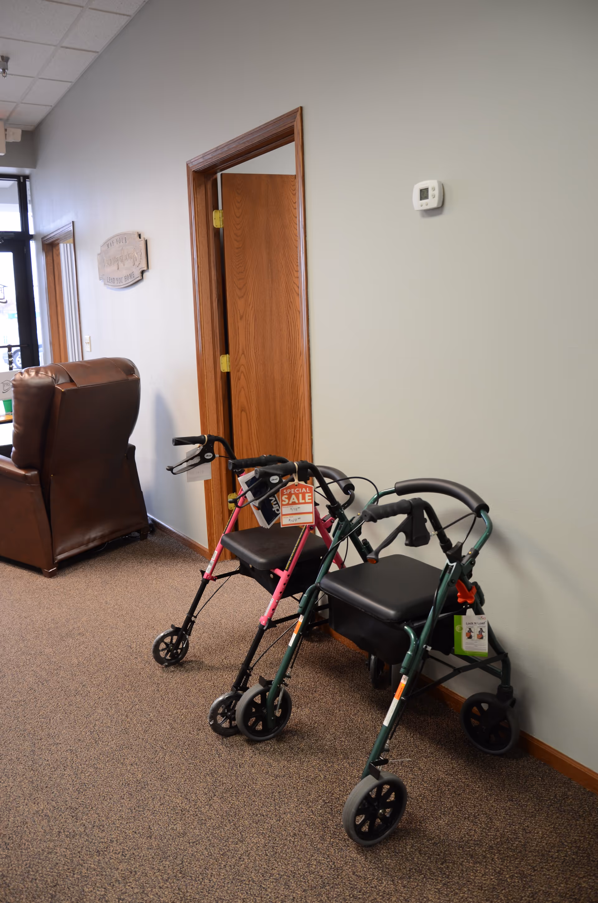Interior hallway of Promedcare facility with several mobility walkers lined up.