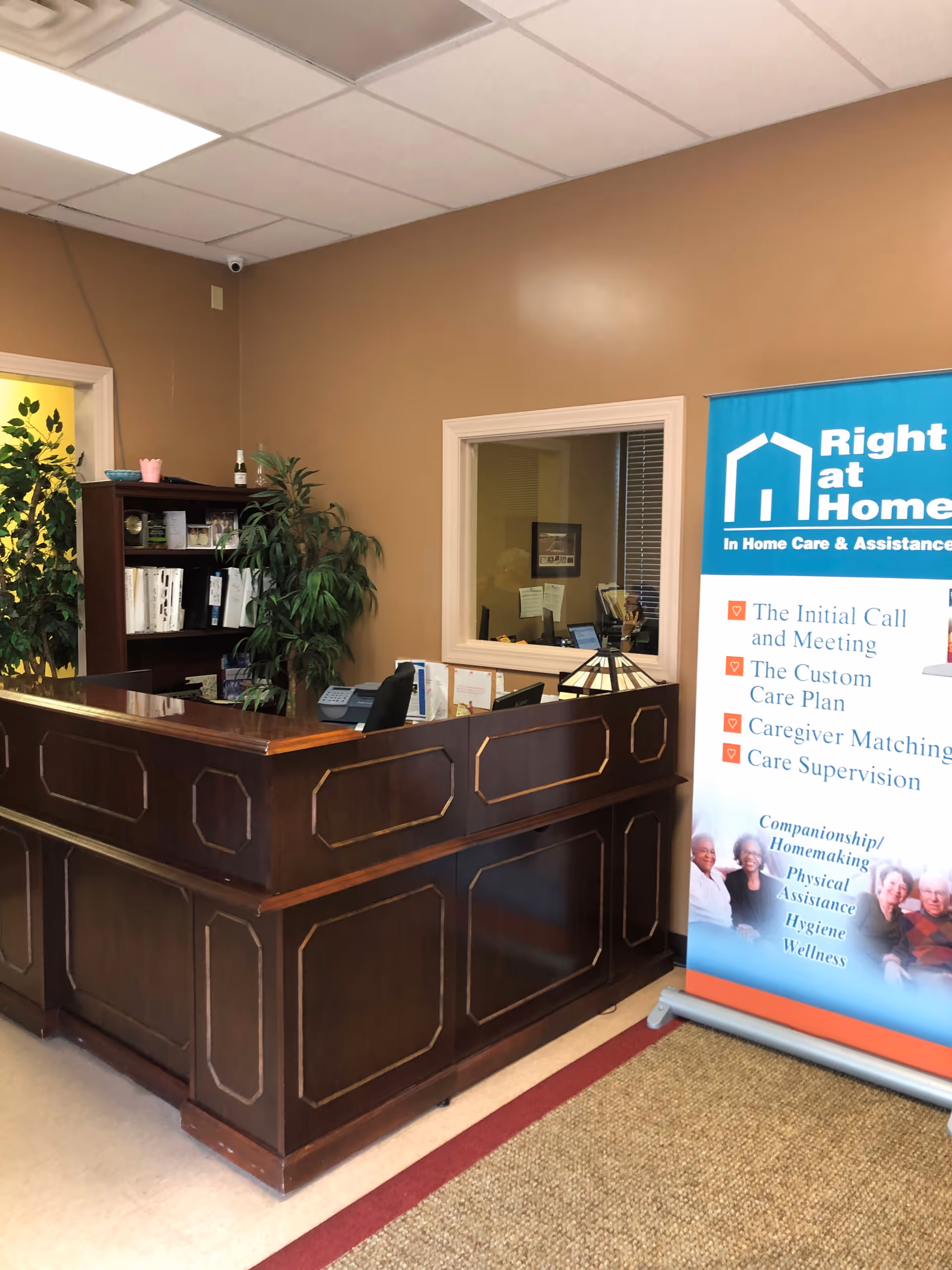 Reception desk in a senior living facility lobby with a Right at Home banner.