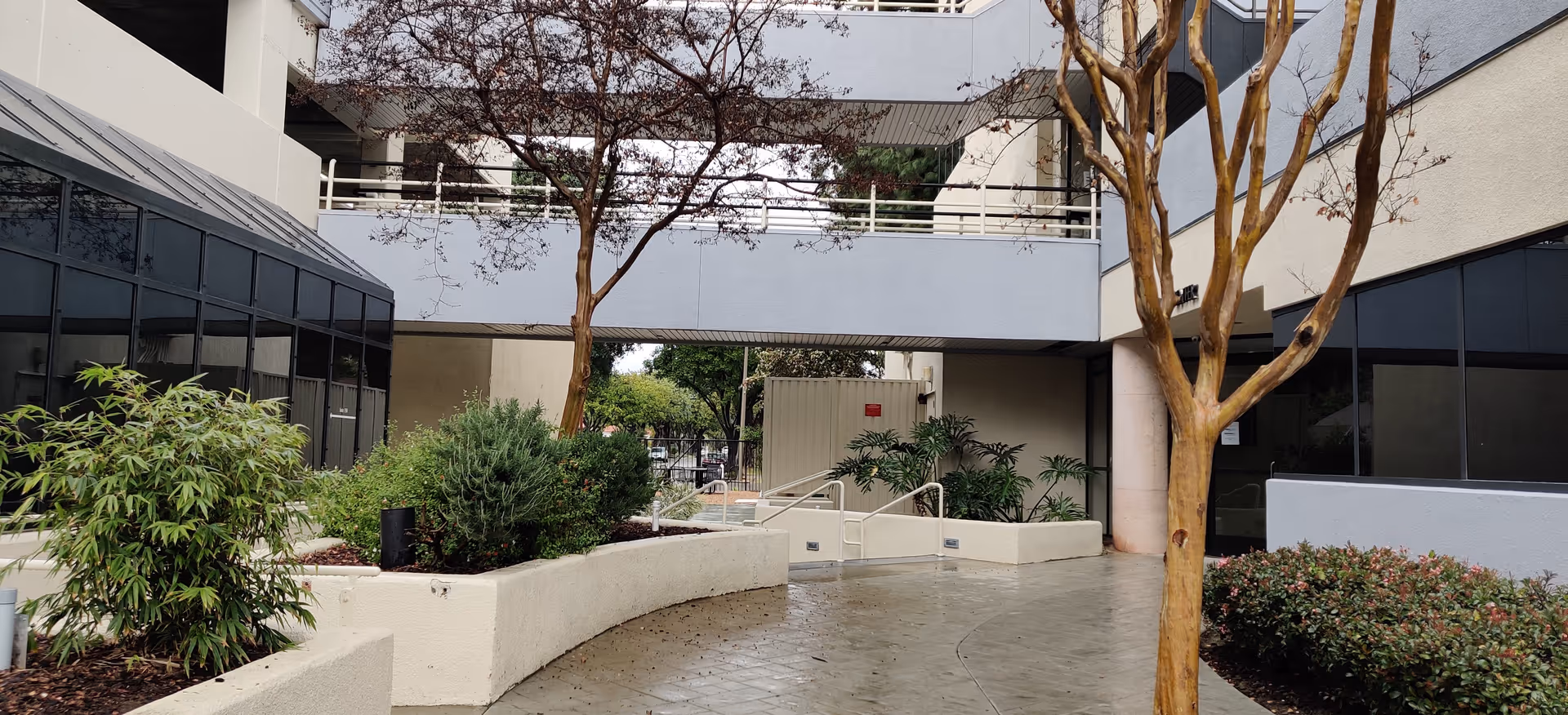 Outdoor courtyard of Hospice and Palliative Care Provider facility with planters and trees.