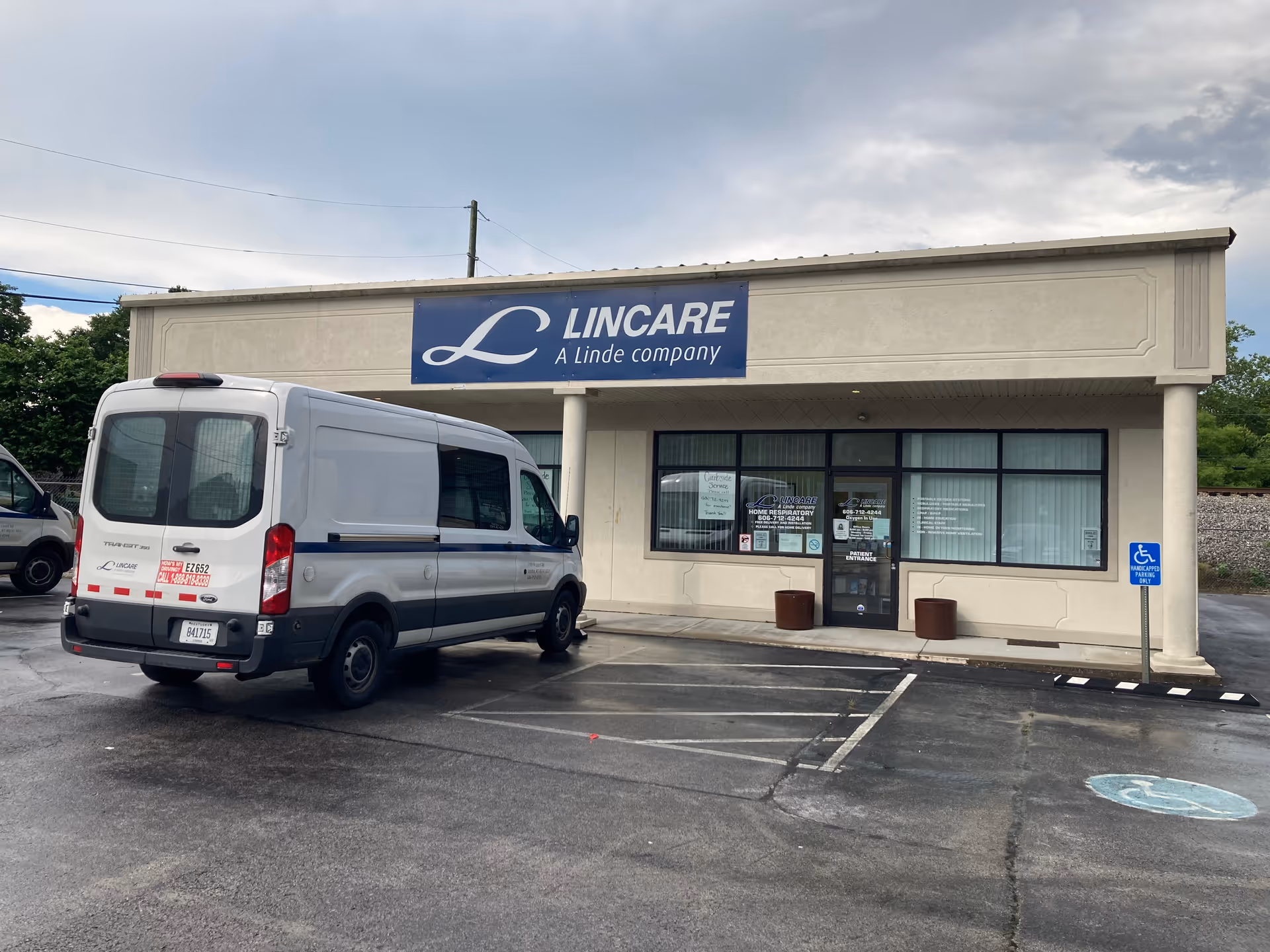 Exterior facade of LINCARE facility with a parked white van in front.
