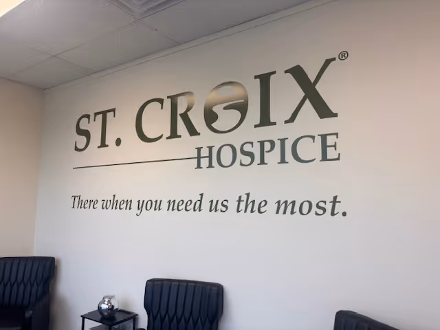 Interior lounge showing St. Croix Hospice logo and blue waiting chairs.