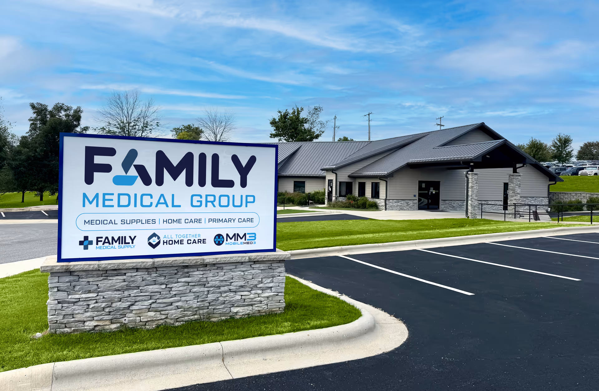 Exterior view of a medical facility with a large Family Medical Group sign and parking lot