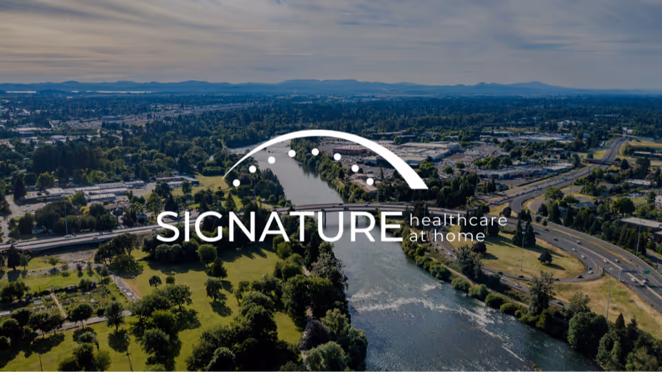 Aerial view of a river and green parks with a Signature Healthcare at Home logo.