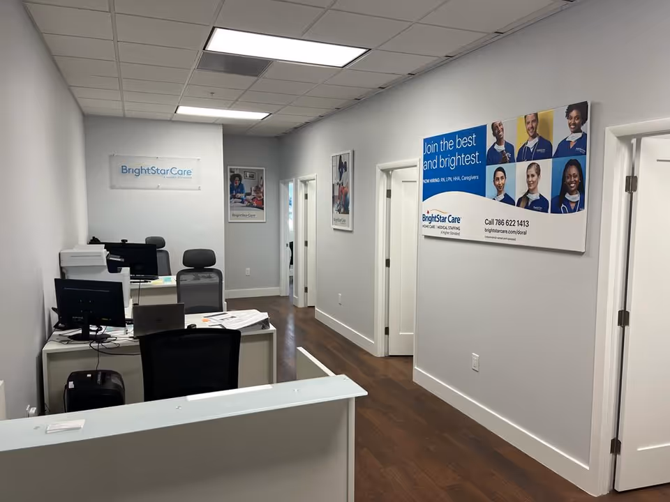 BrightStar Care office area with desks, computers, chairs, and wall posters.