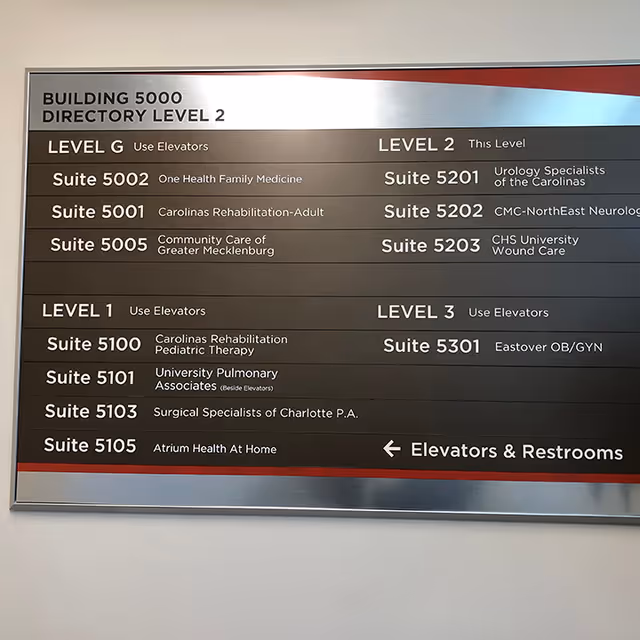 Interior building directory sign listing levels and suites for Atrium Health At Home
