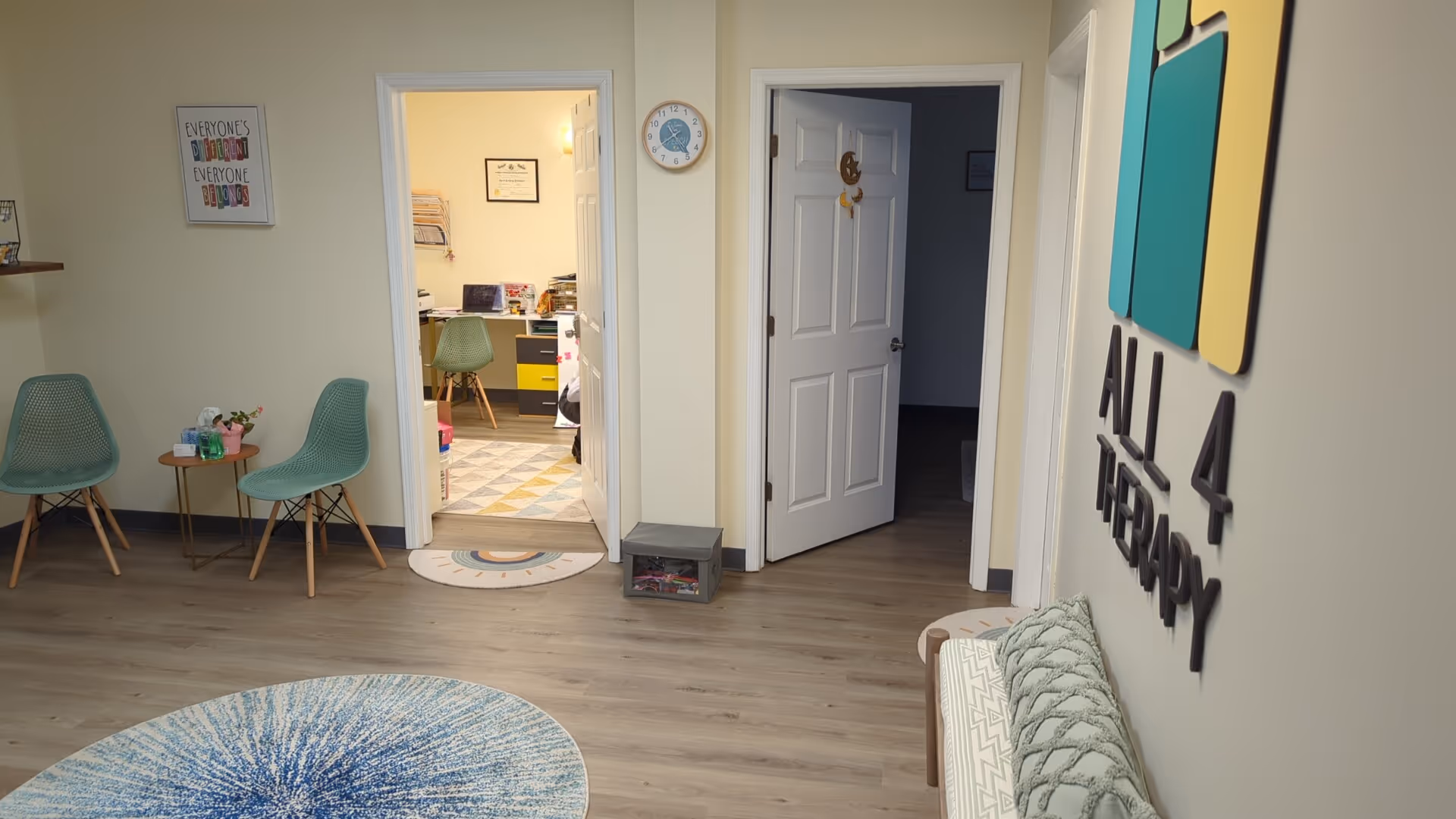 Entrance lounge of a senior facility with mint chairs, wall signage, and doorways to therapy rooms.