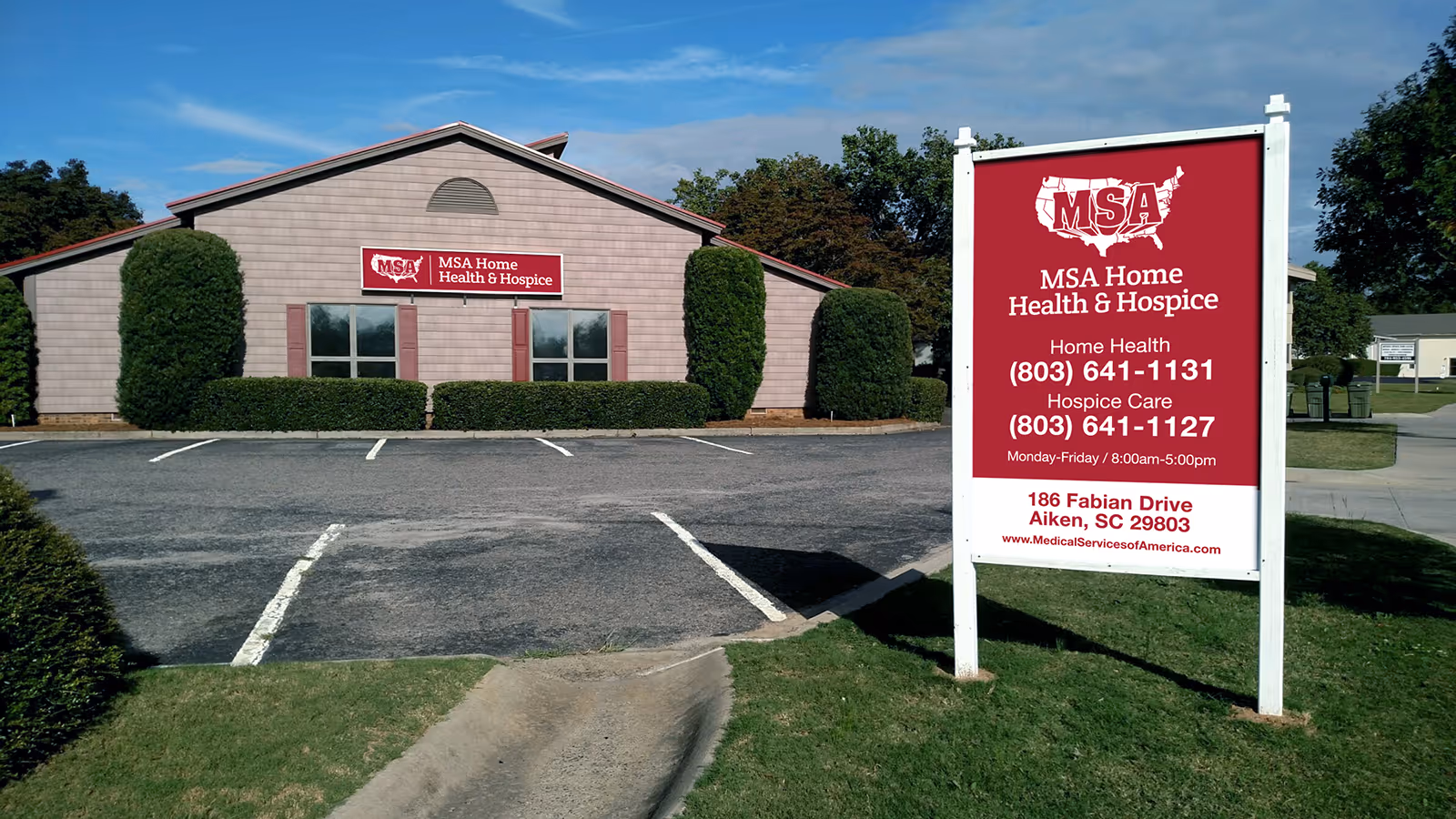 A single-story pink building with a red MSA Home Health & Hospice sign in parking lot.