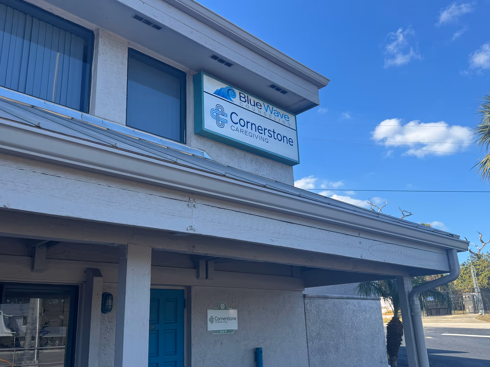 Exterior of a Cornerstone Caregiving building with signage against blue sky