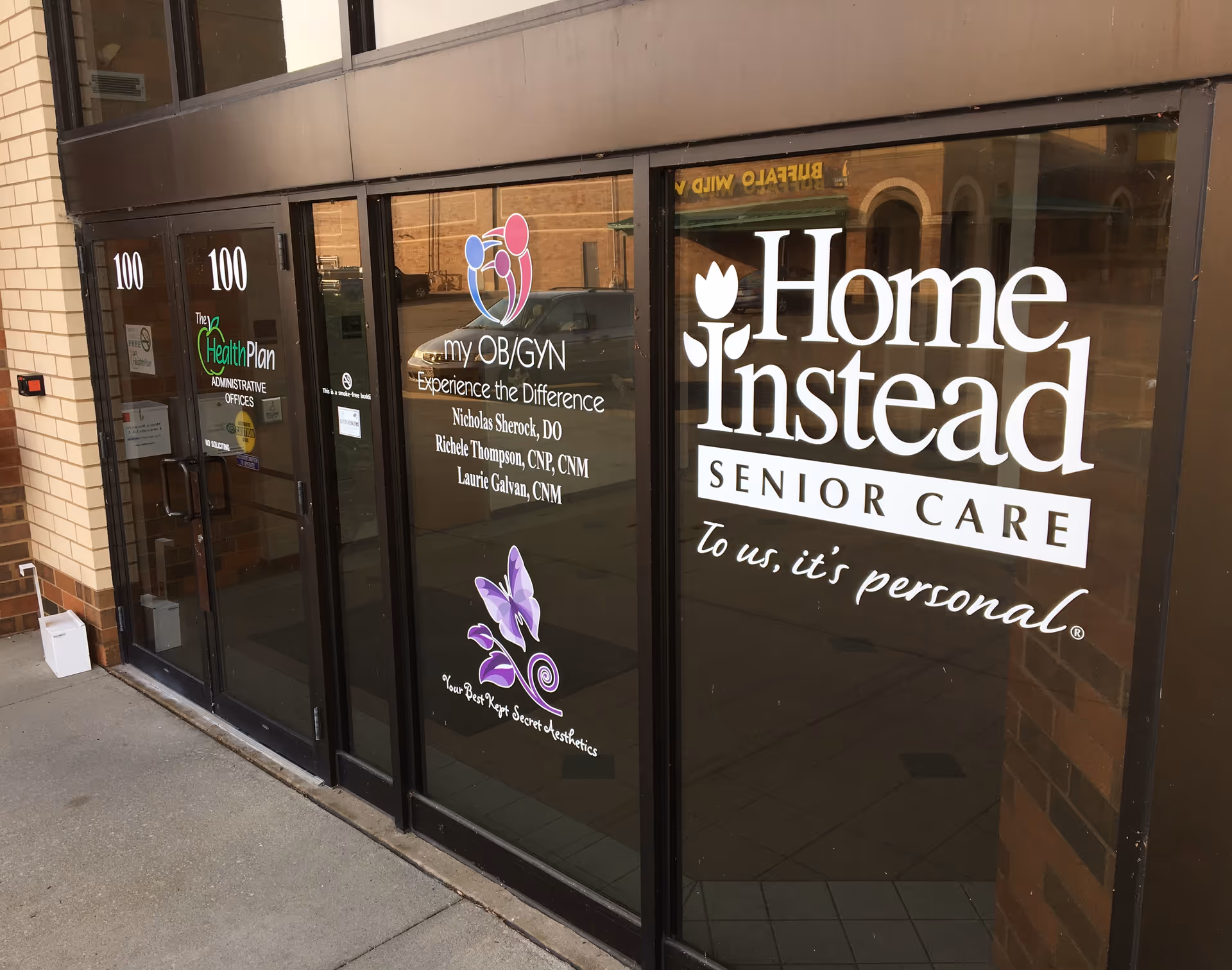 Exterior glass doors display Home Instead Senior Care signage and logos.