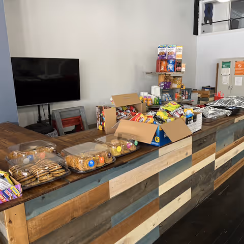 Indoor reception area with a snack counter, boxed goods, and shelves of snacks.