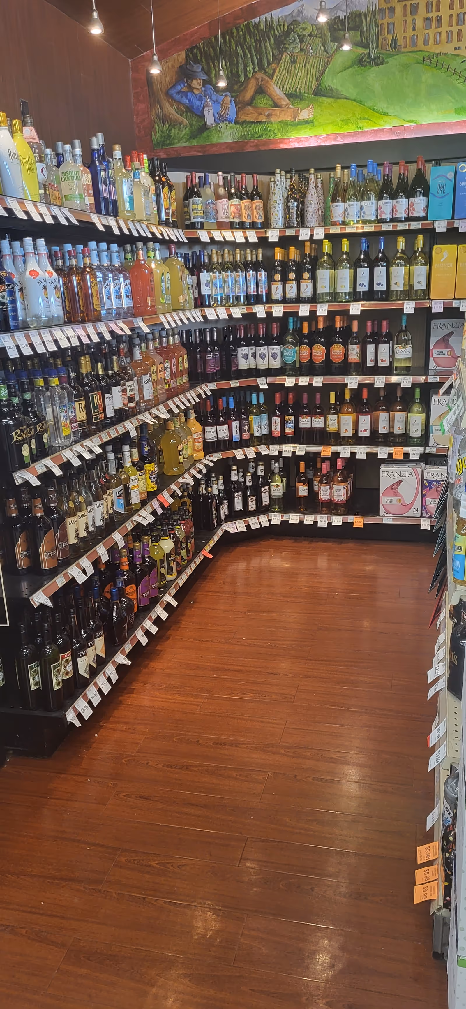 Liquor bottles line curved shelves inside Discount Drug Mart.