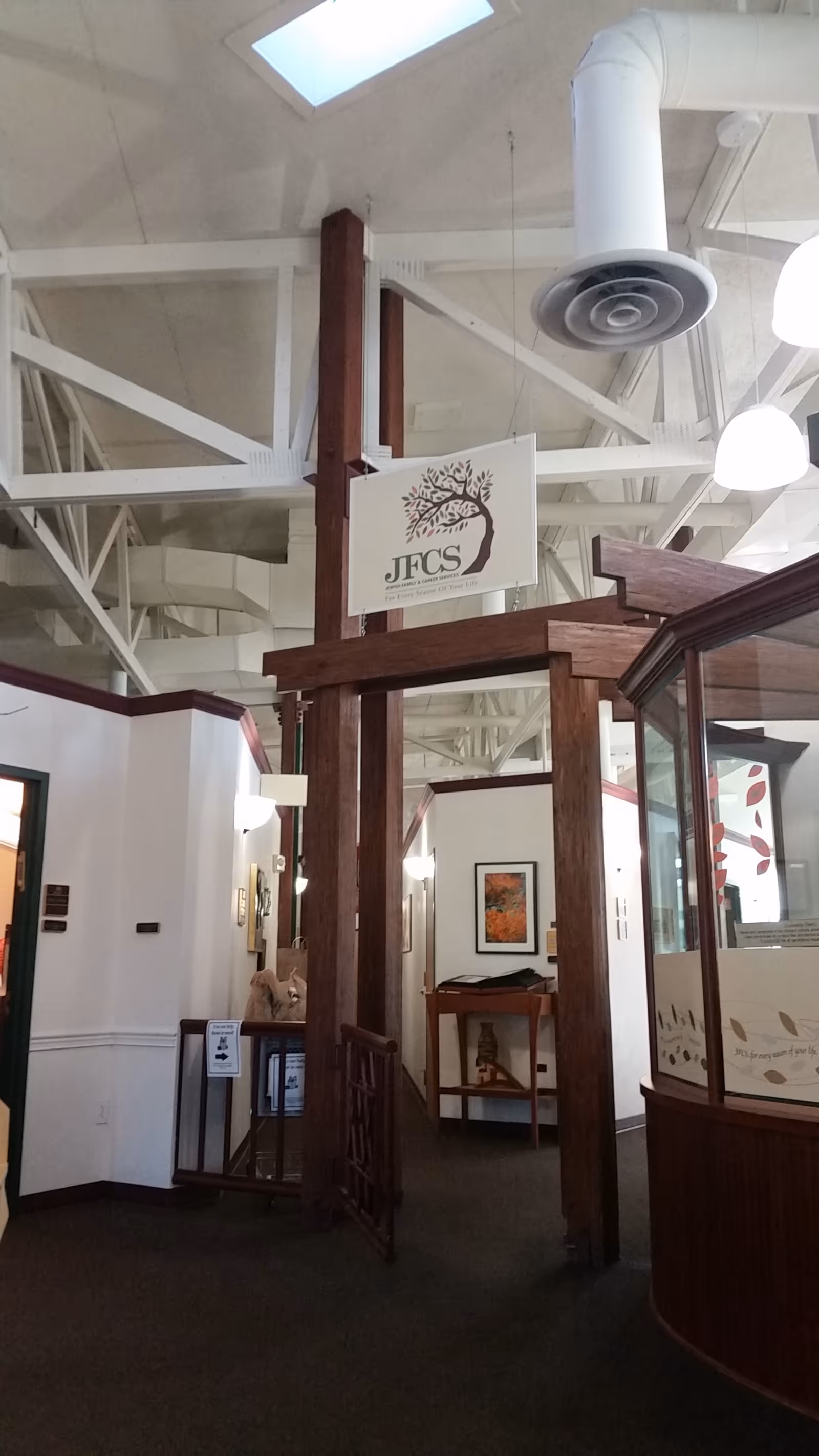 Interior hallway at Jewish Family & Career Services with wood archway and sign.