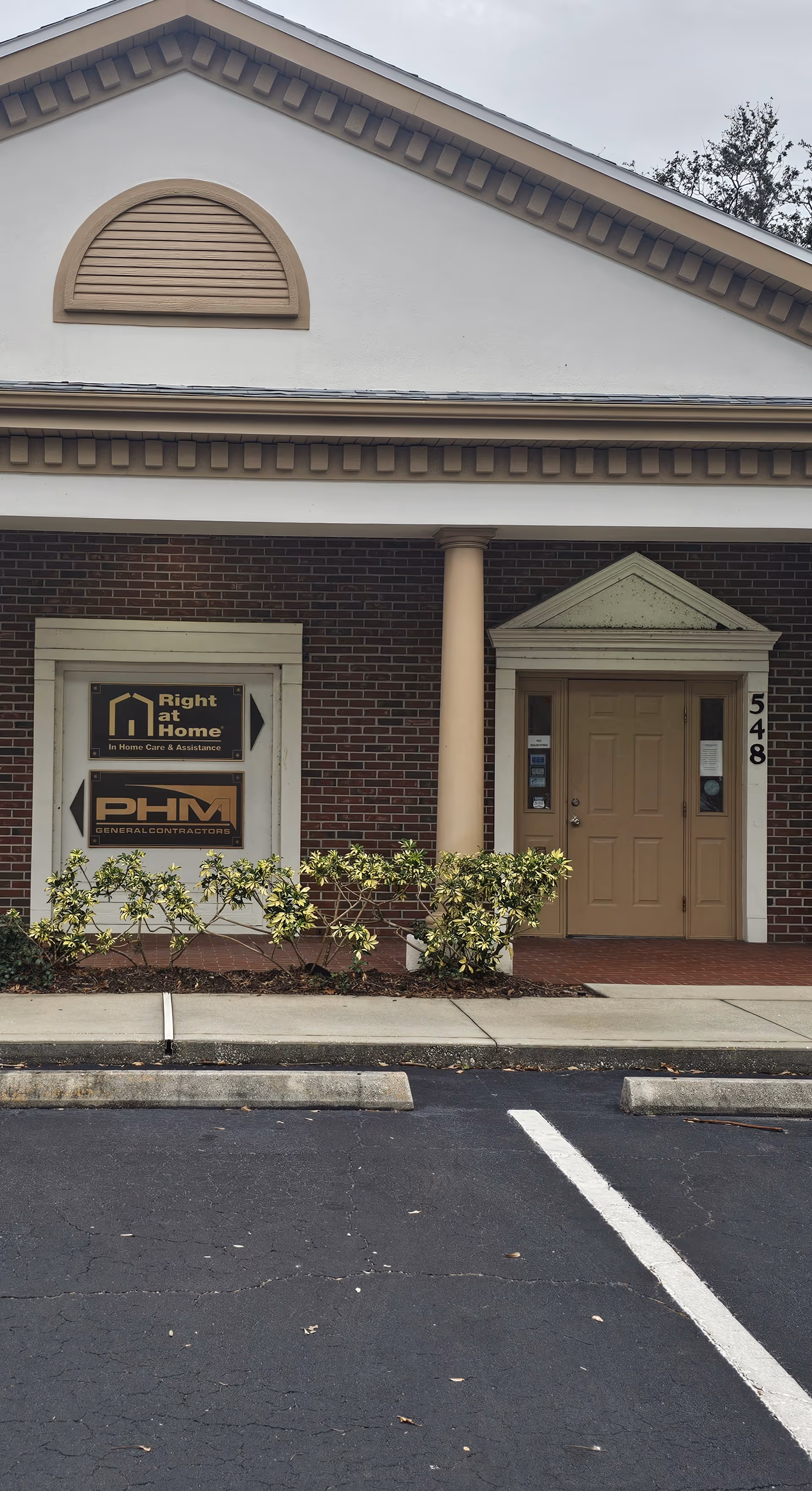 Front exterior of a Right at Home building with beige door and signs.