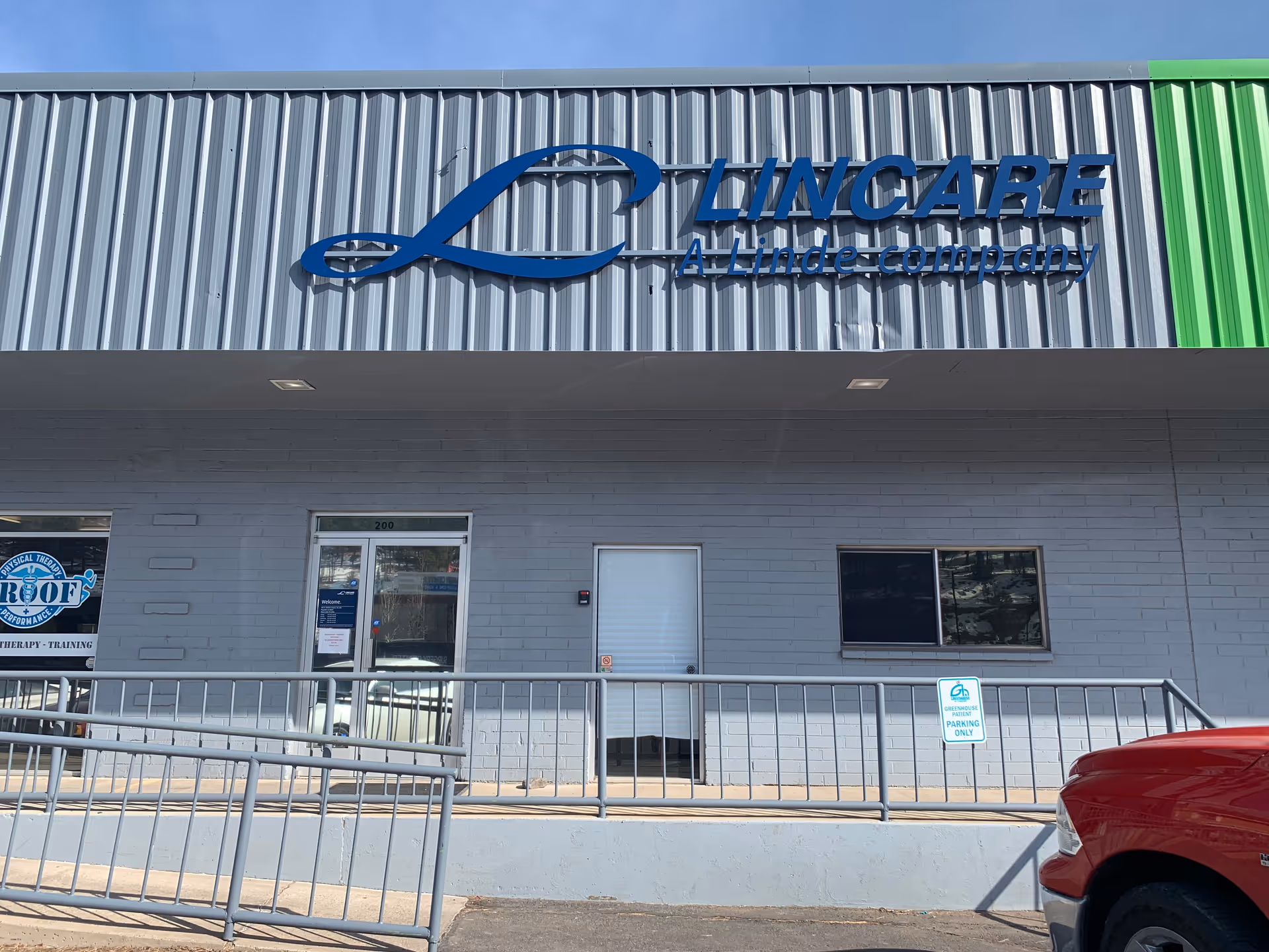 Exterior storefront of a LINCARE facility with ramp, sign, and parking lot.