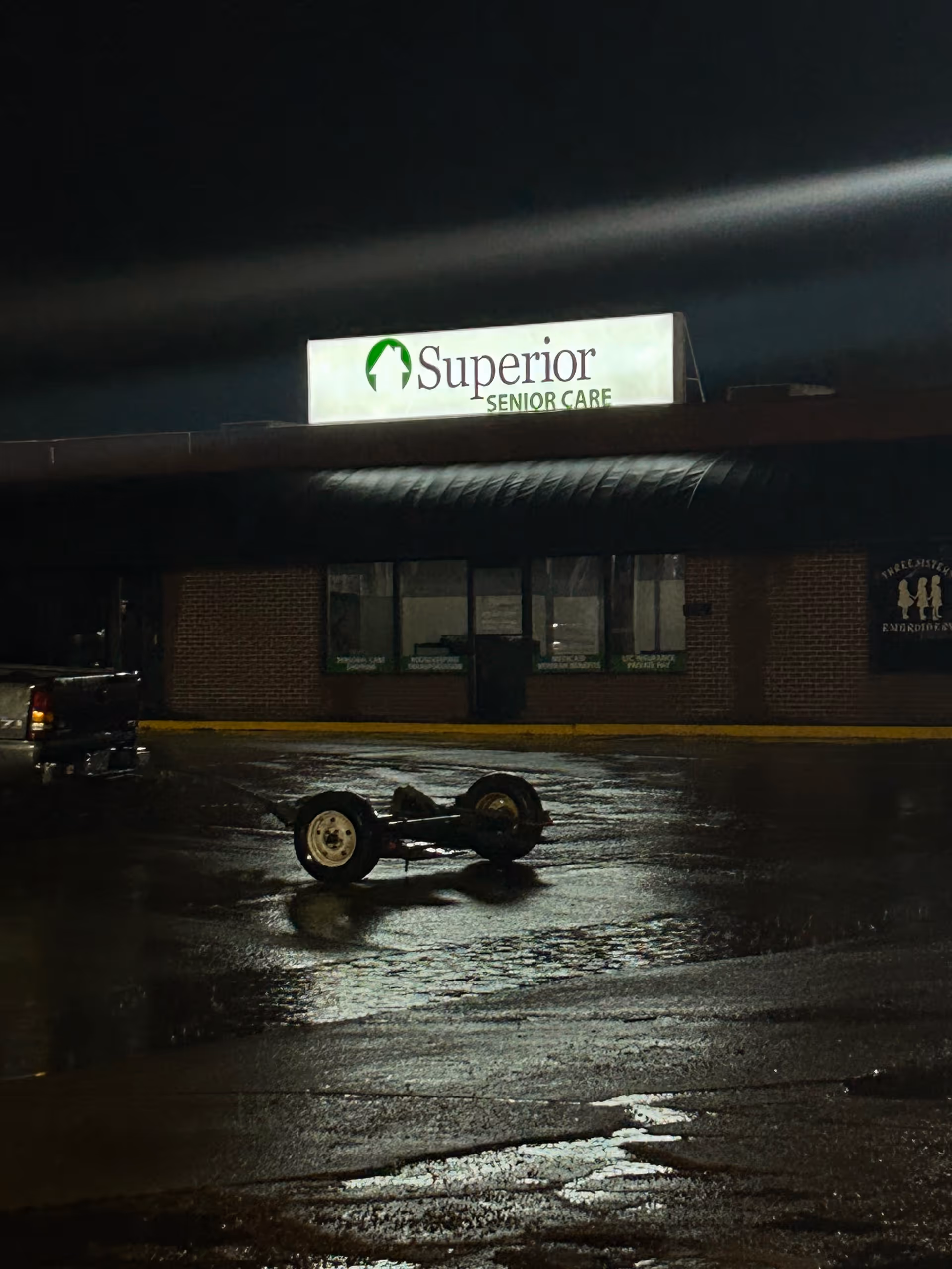 Night exterior of a building with a Superior Senior Care sign and a trailer.