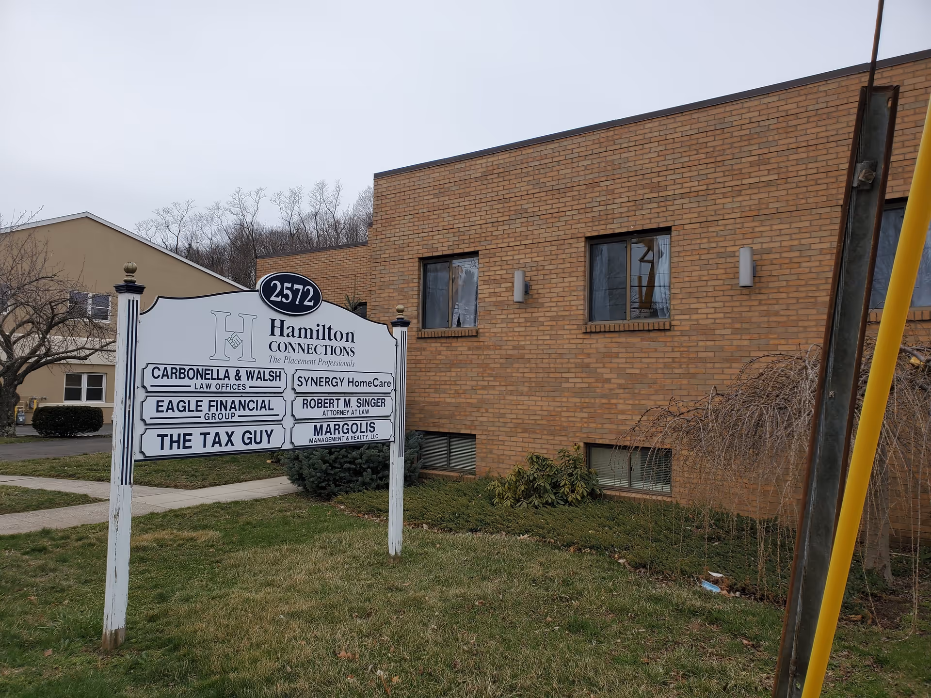 Brick office building with a large tenant sign, including SYNERGY HomeCare.