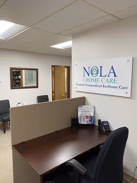 Reception desk in an office area with a NOLA @ Home Care sign.