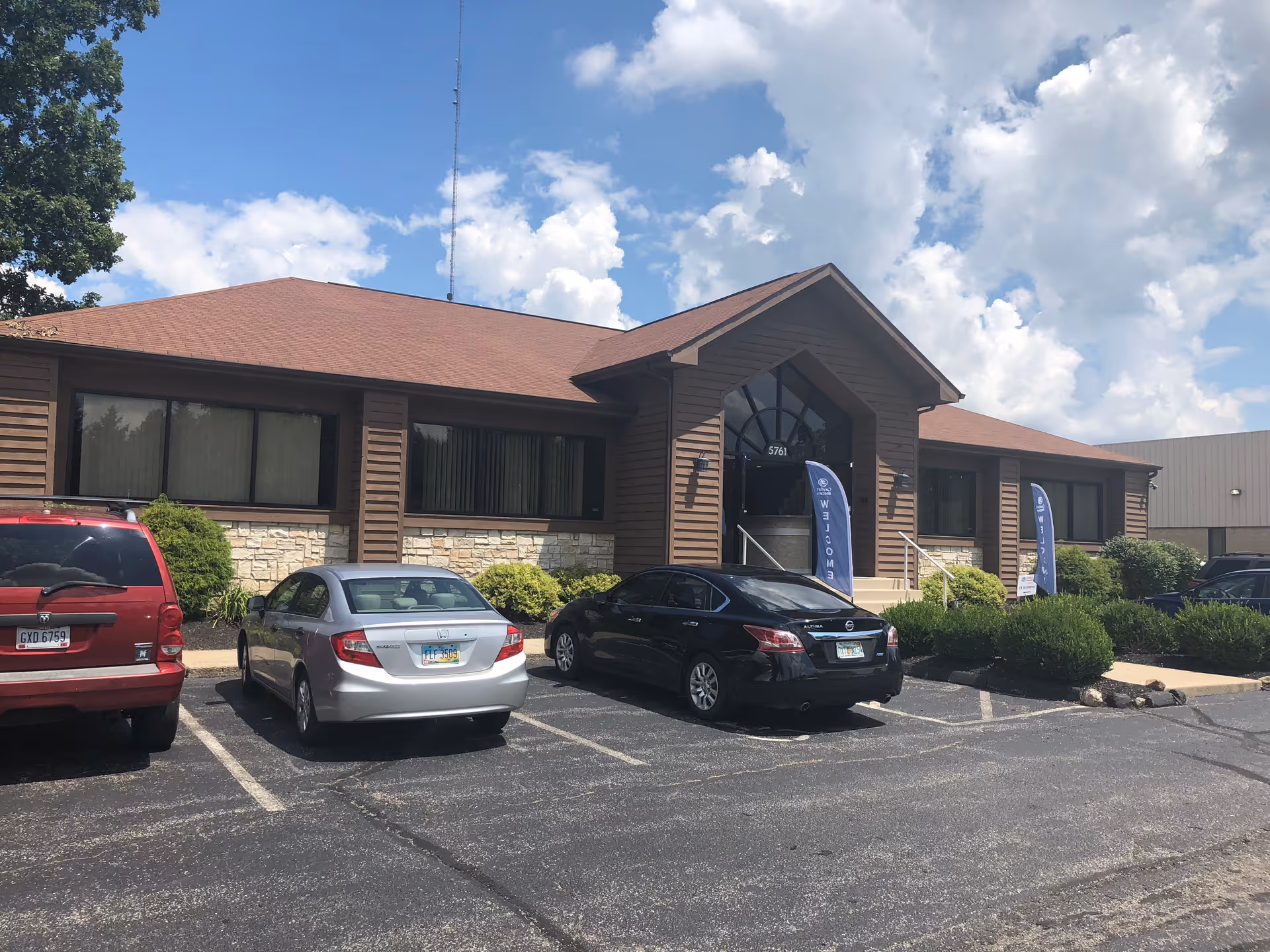 Wide view of Comfort Keepers building exterior with parked cars by the entrance.