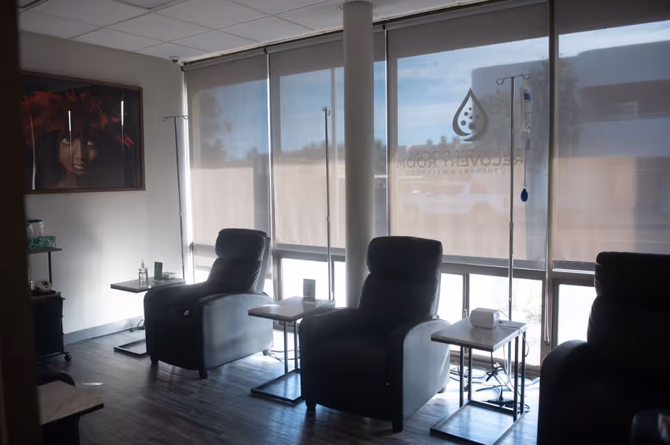 Infusion chairs and IV stands in a sunlit treatment room.
