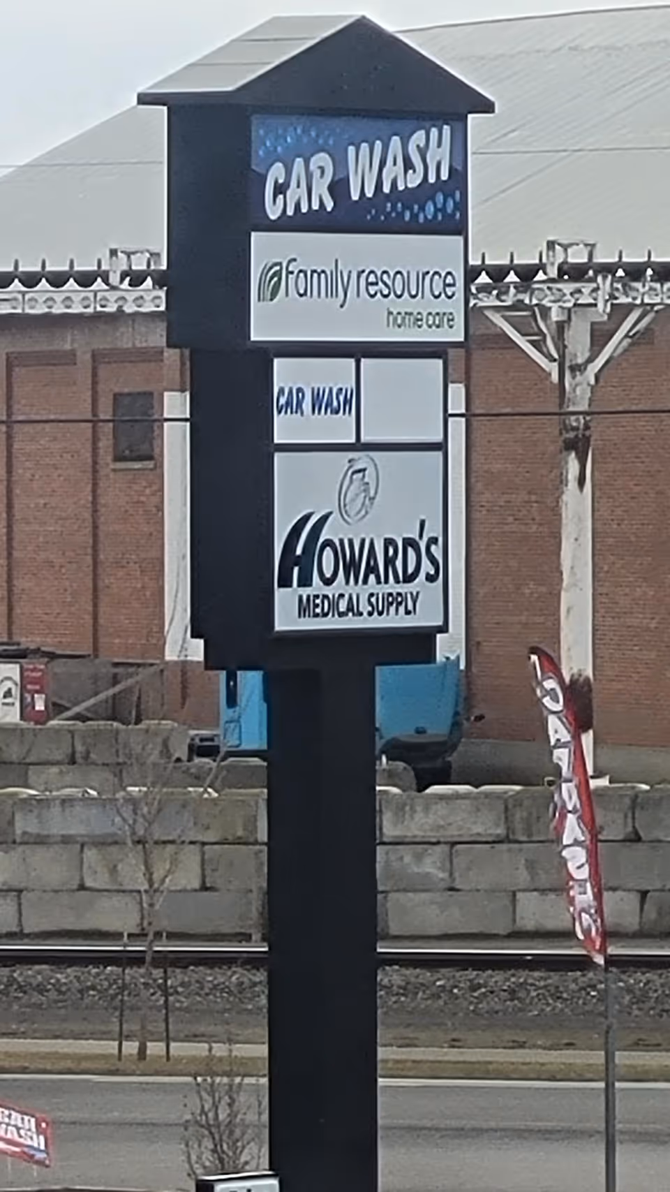 Outdoor sign for Family Resource Home Care with car wash and Howard's Medical Supply.