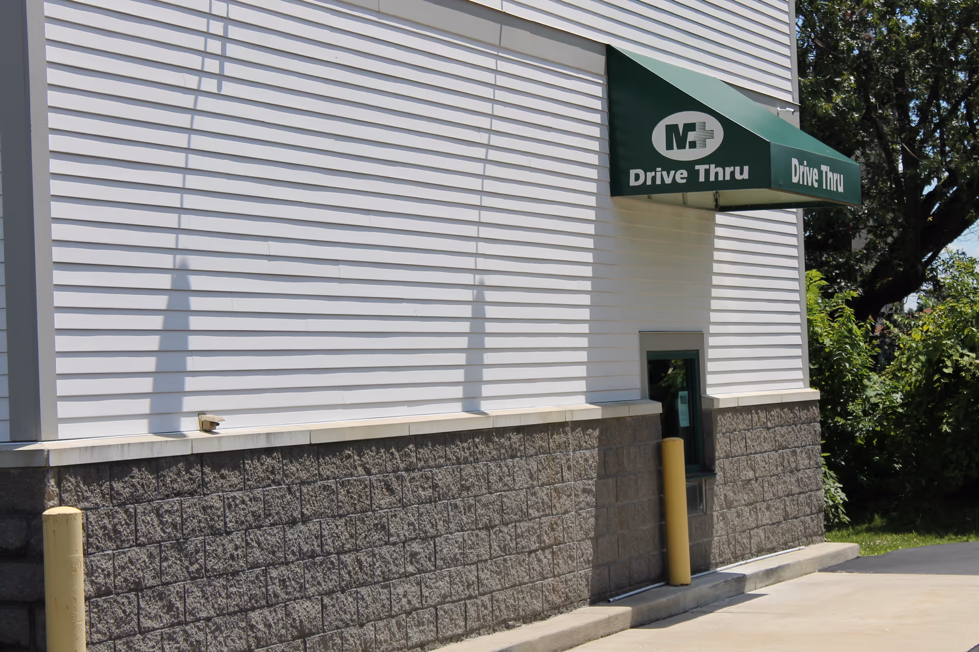 White building exterior of Mullaney's JANZ Medical Supply with a green drive-thru awning.