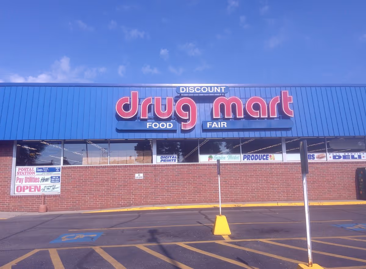 Blue Discount Drug Mart storefront with large red logo and brick exterior