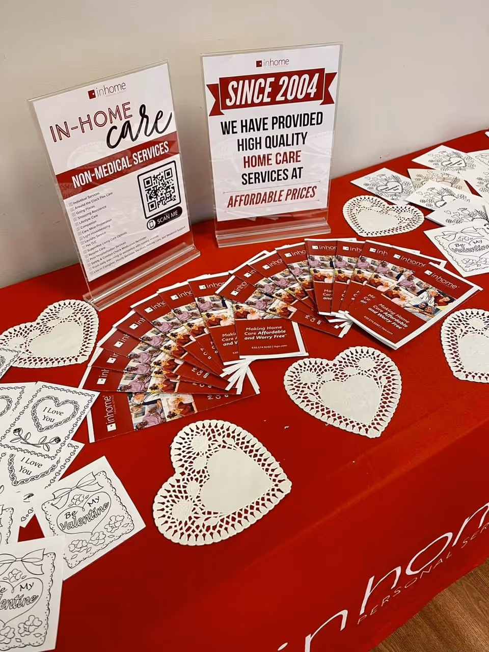 Promotional table with In-Home Care brochures and heart-shaped decorations.