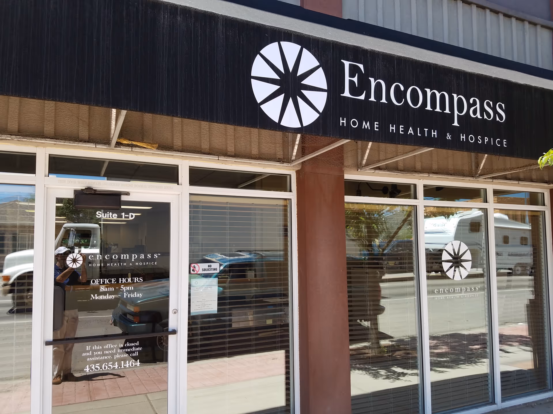 Exterior storefront of Encompass Home Health & Hospice with glass doors and logo.