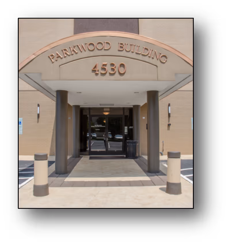 View of Parkwood Building entrance with arches, pillars, and glass doors, 4530 address.