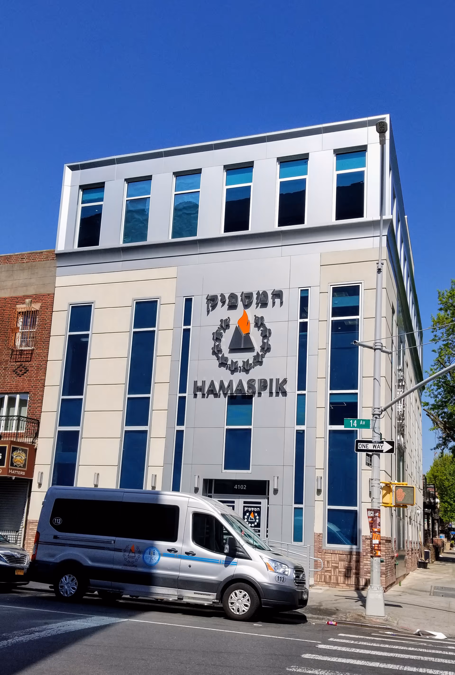 Modern Hamaspik HomeCare building facade with logo and a white van parked outside.