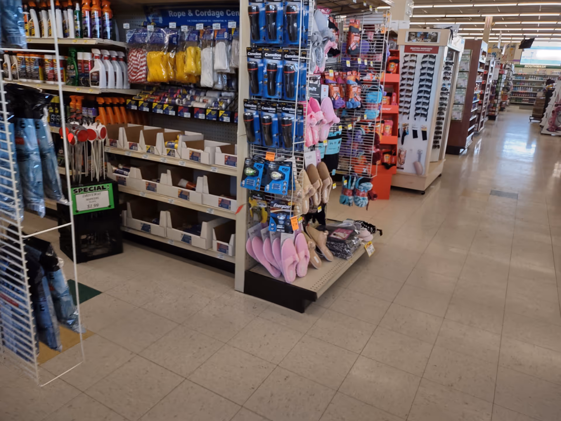 Inside a Discount Drug Mart store, aisles stocked with cleaning products and footwear.