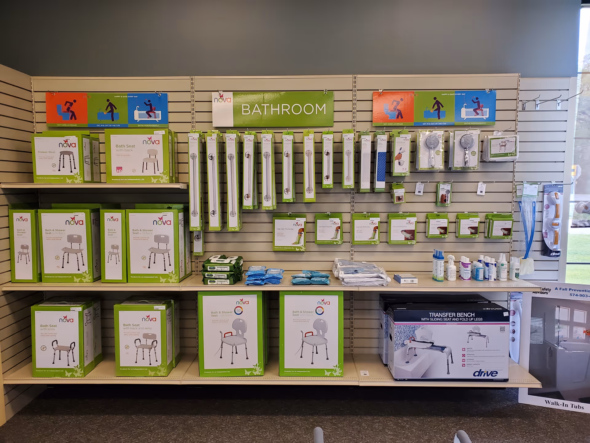 Indoor retail display of bathroom safety products and assistive devices on slatwall panels.