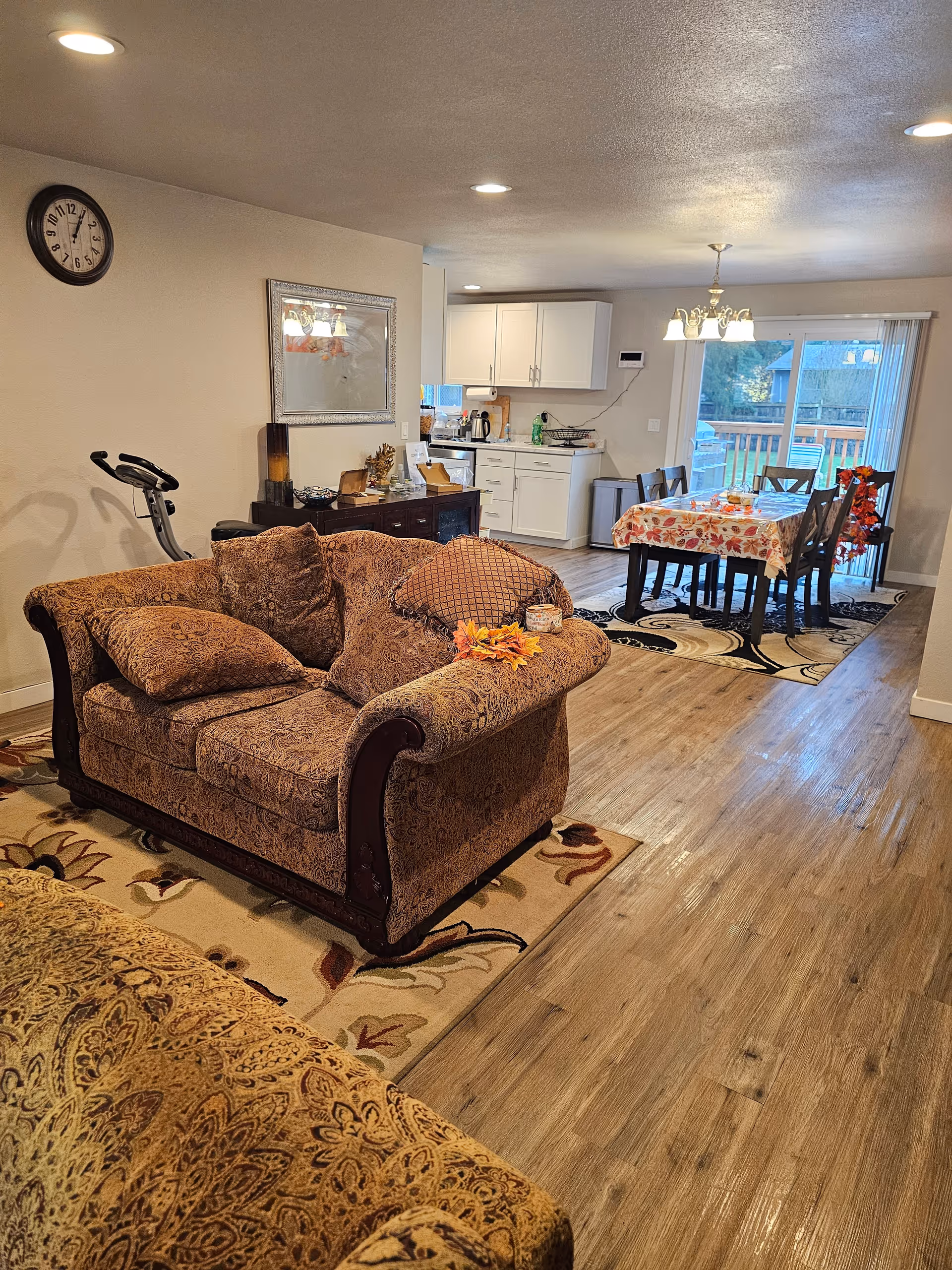 Cozy living room in a senior facility with patterned sofa and open dining area.