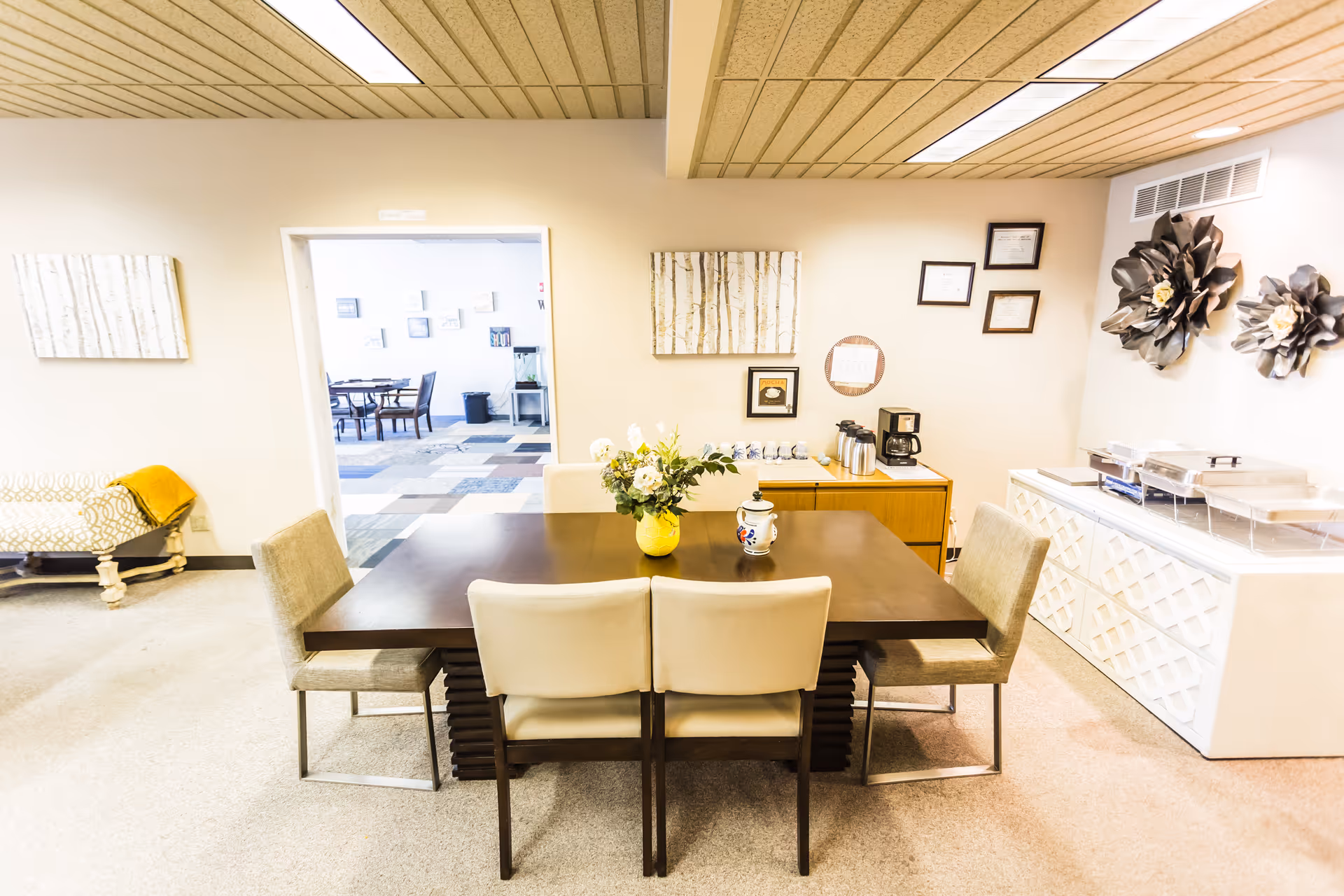 Interior dining area in a senior facility with a large table, chairs, and serving station.