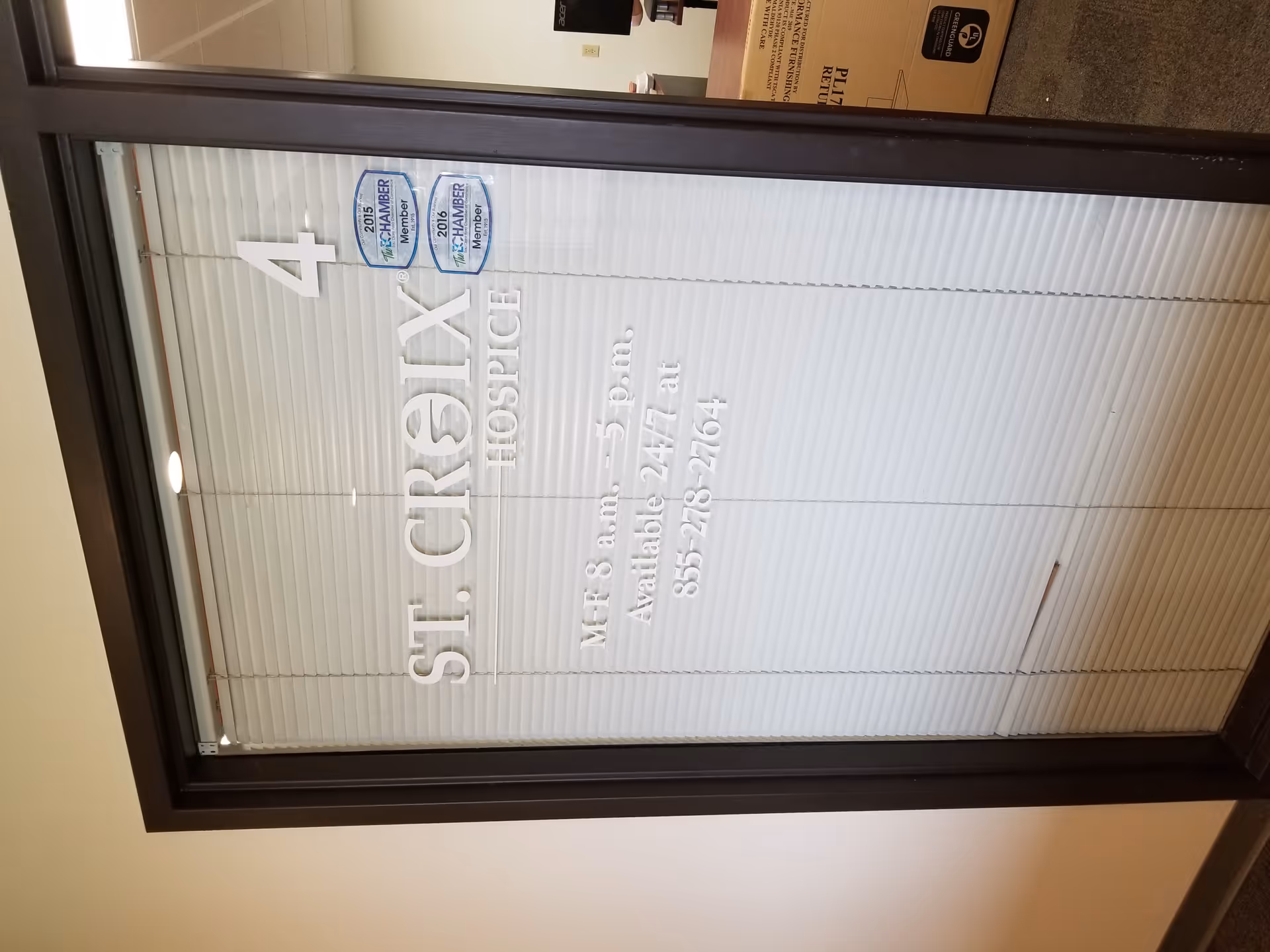 Interior glass door with blinds, displaying St. Croix Hospice branding and a large 4.