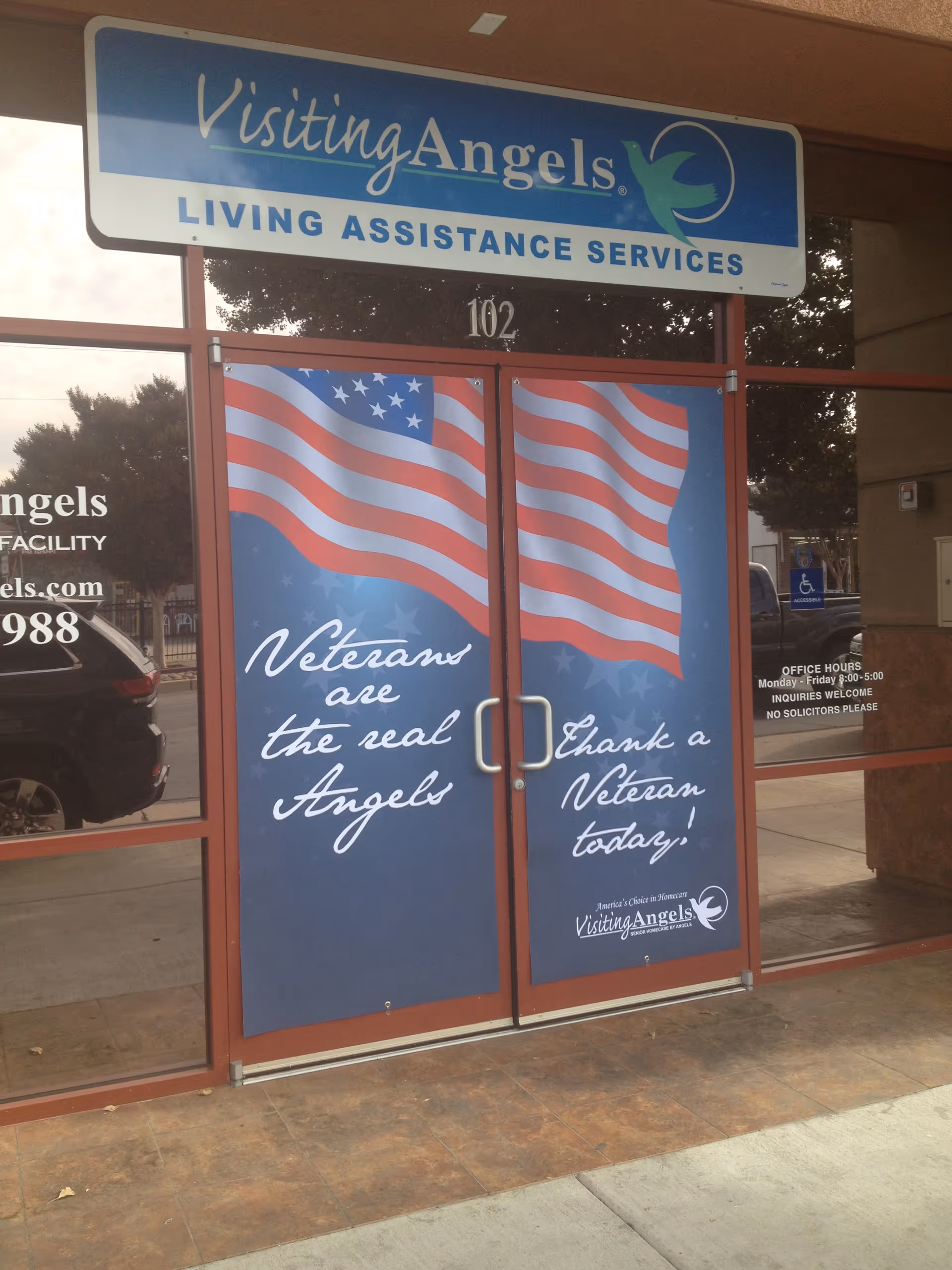 Front entrance of Visiting Angels with patriotic banners on the doors.