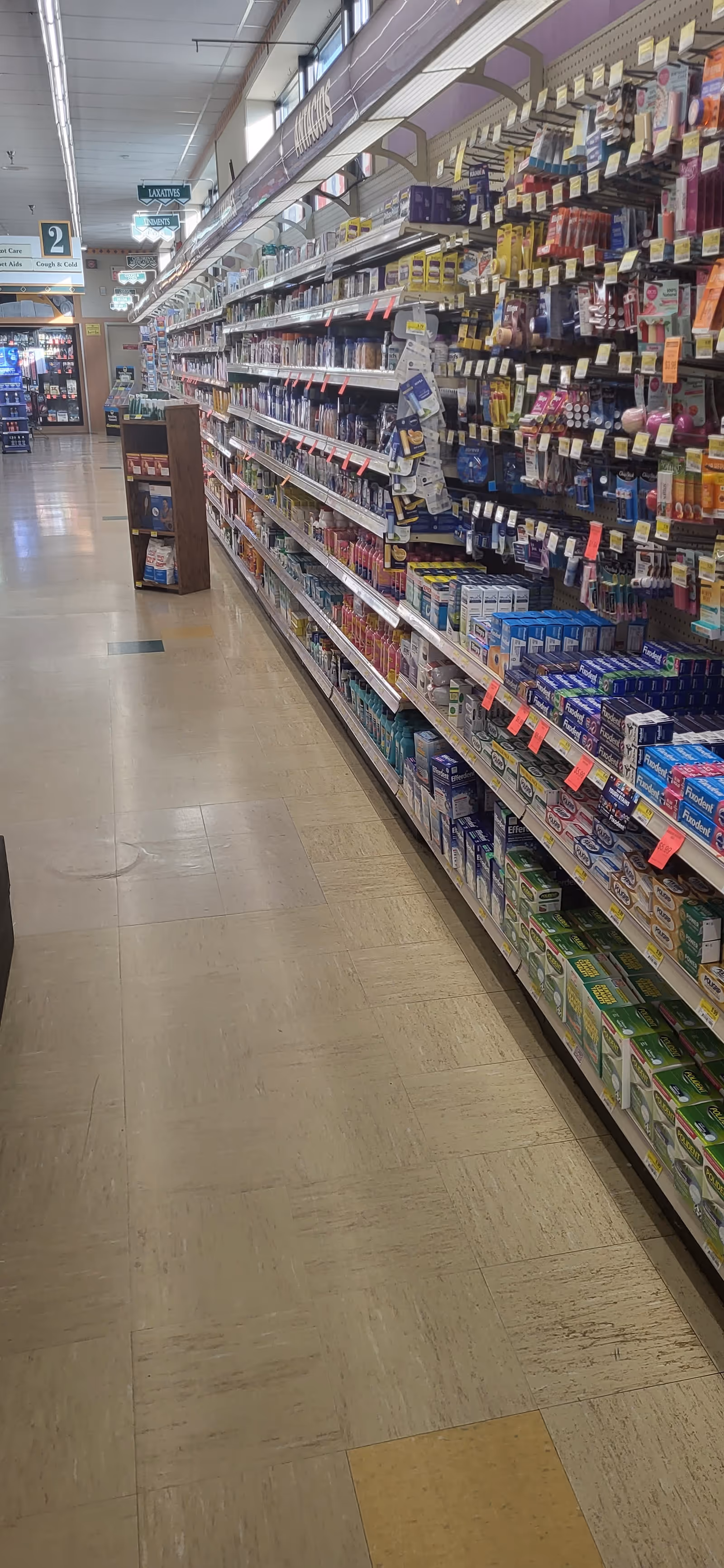 A long Discount Drug Mart aisle with shelves stocked on both sides.