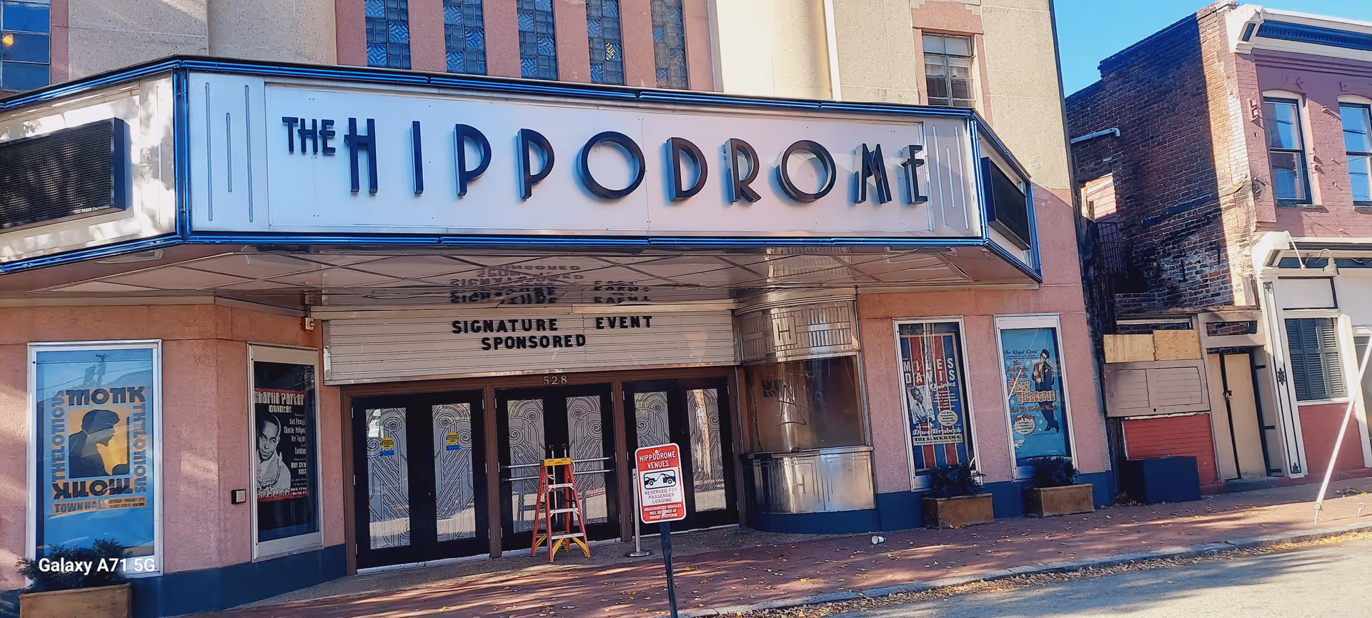 The Hippodrome theater front with marquee, closed doors, theater posters, and street scene.