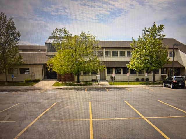 Exterior view of a Comfort Keepers Home Care building with a parking lot.