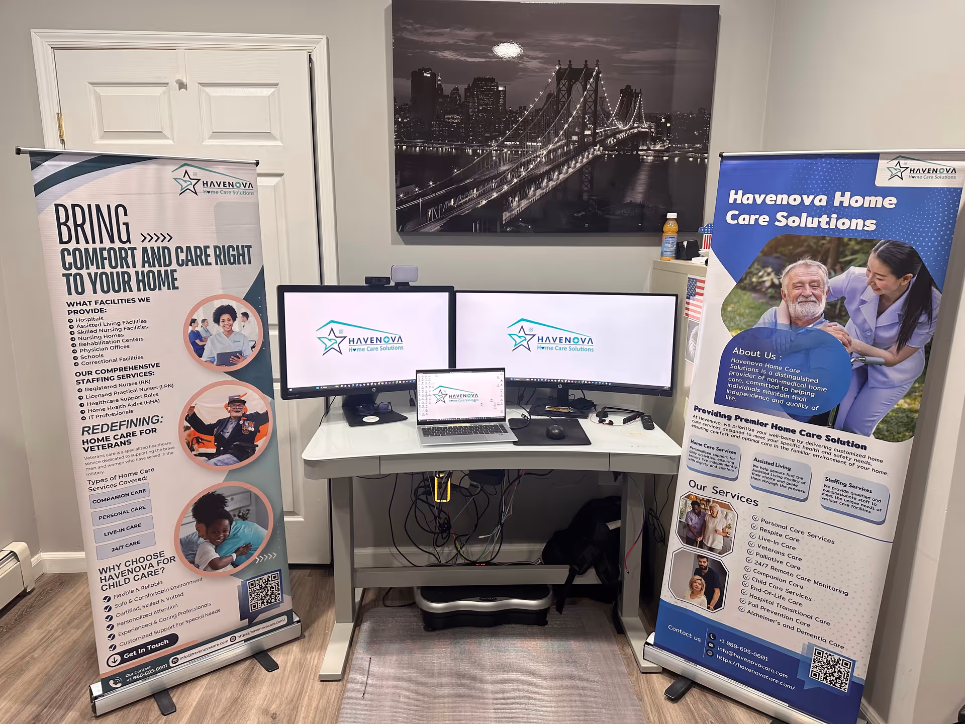 Interior workstation with three monitors and Havenova banners in a senior care facility.
