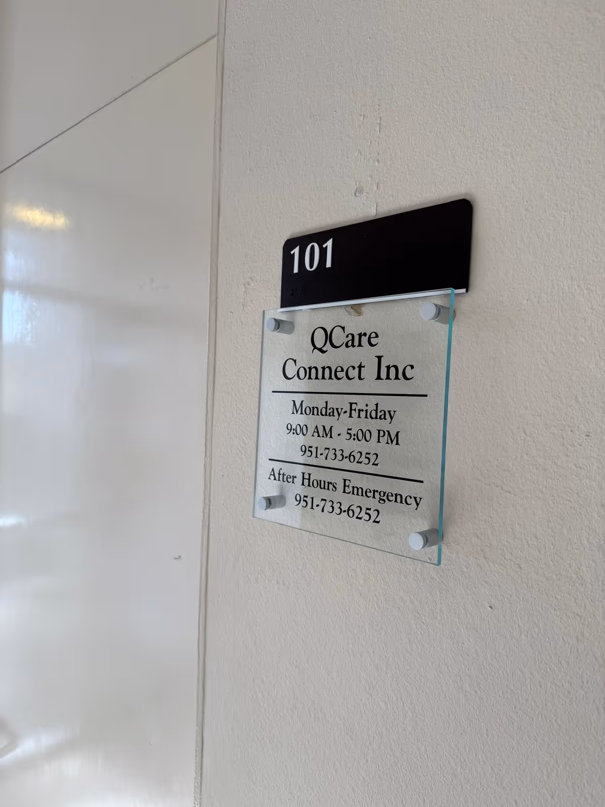 Interior wall showing room number 101 and a QCare Connect Inc sign plaque.