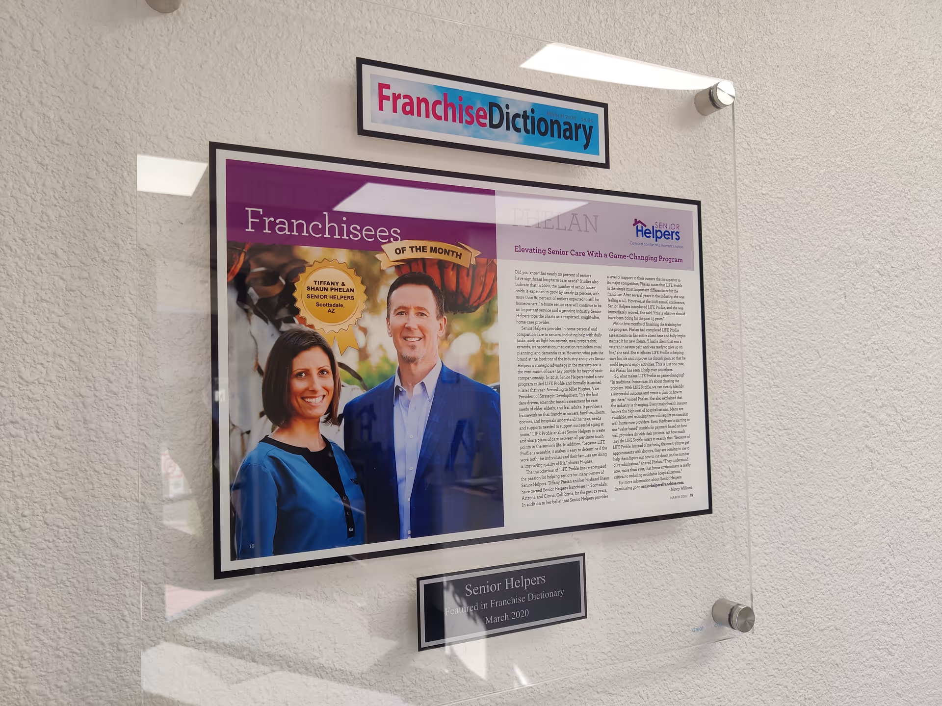 Framed Franchise Dictionary display on a textured wall inside Senior Helpers facility.