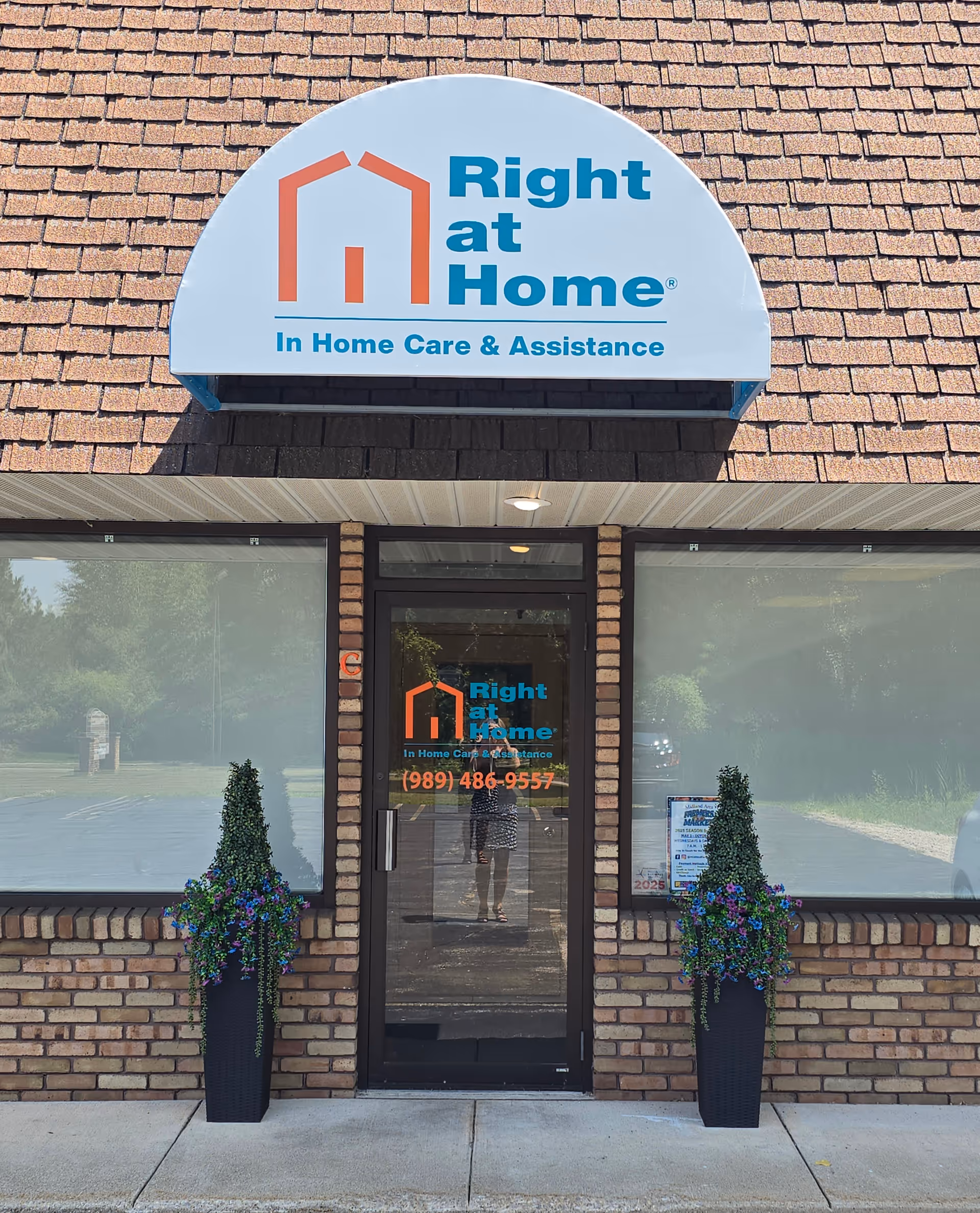 Front view of a brick building with Right at Home sign and planters.