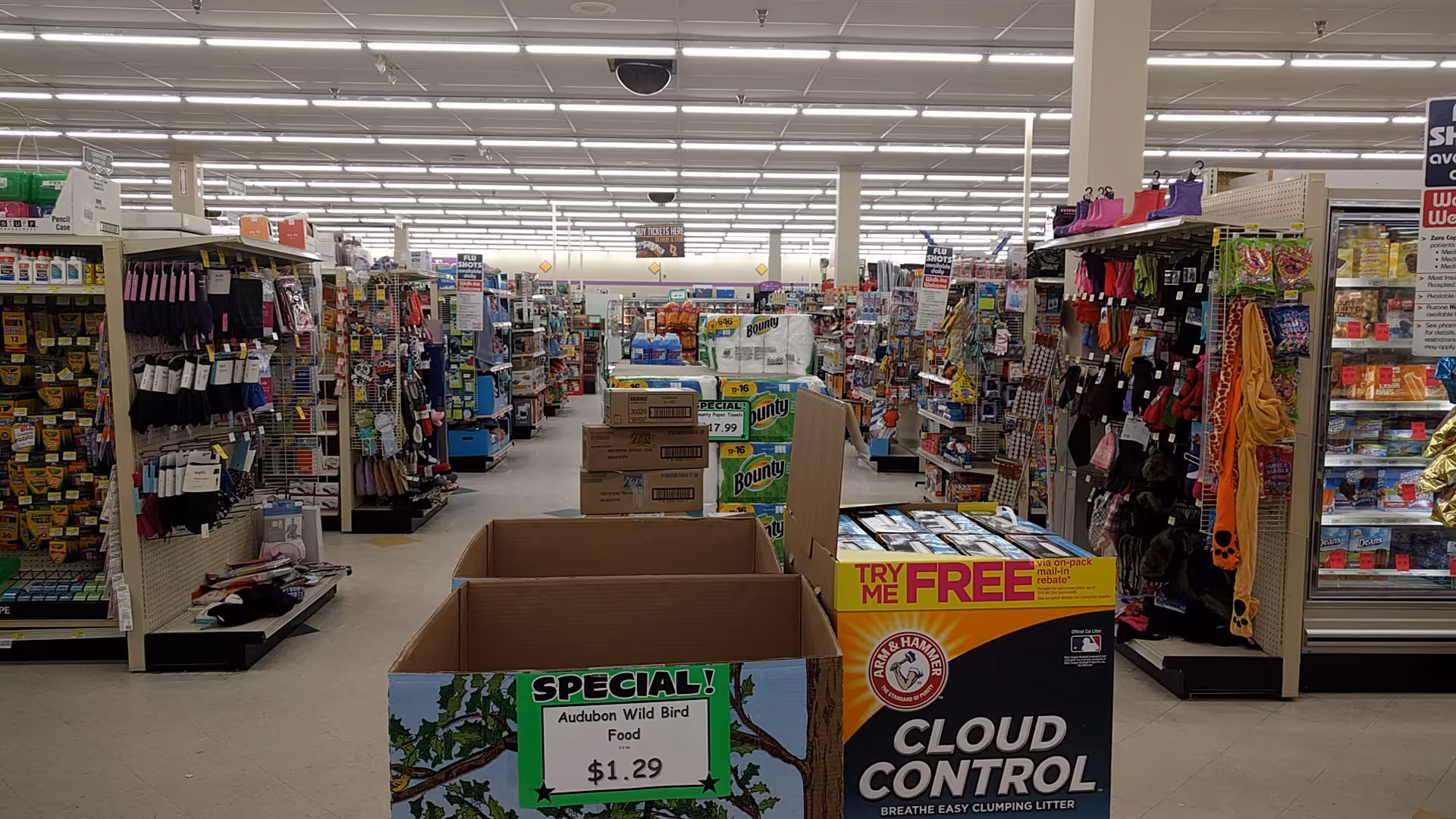 Inside a Discount Drug Mart store with aisles, shelves, and display boxes in the center.